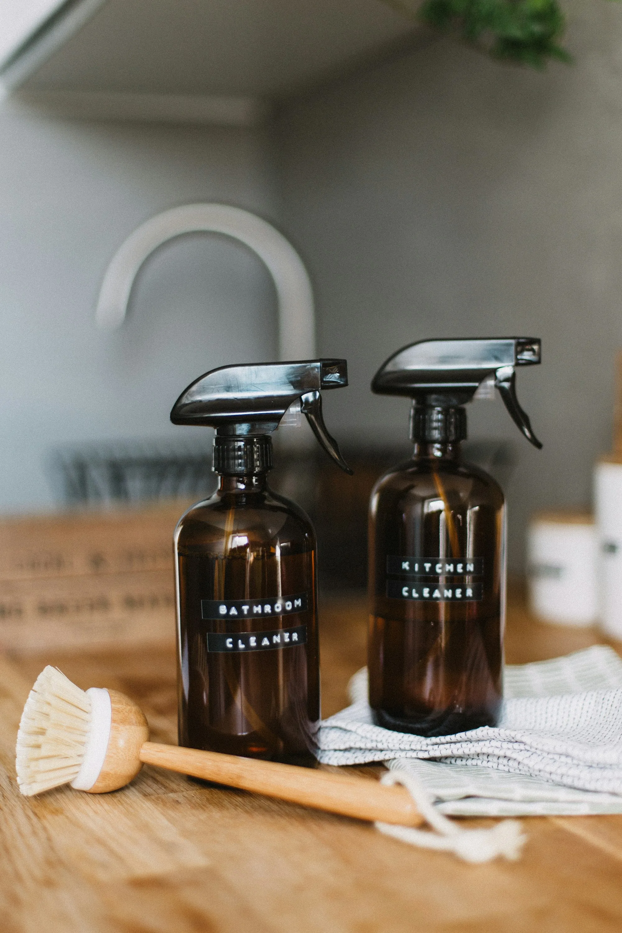 Amber spray bottles labeled for bathroom and kitchen cleaning